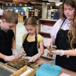 Three kids select type blocks.